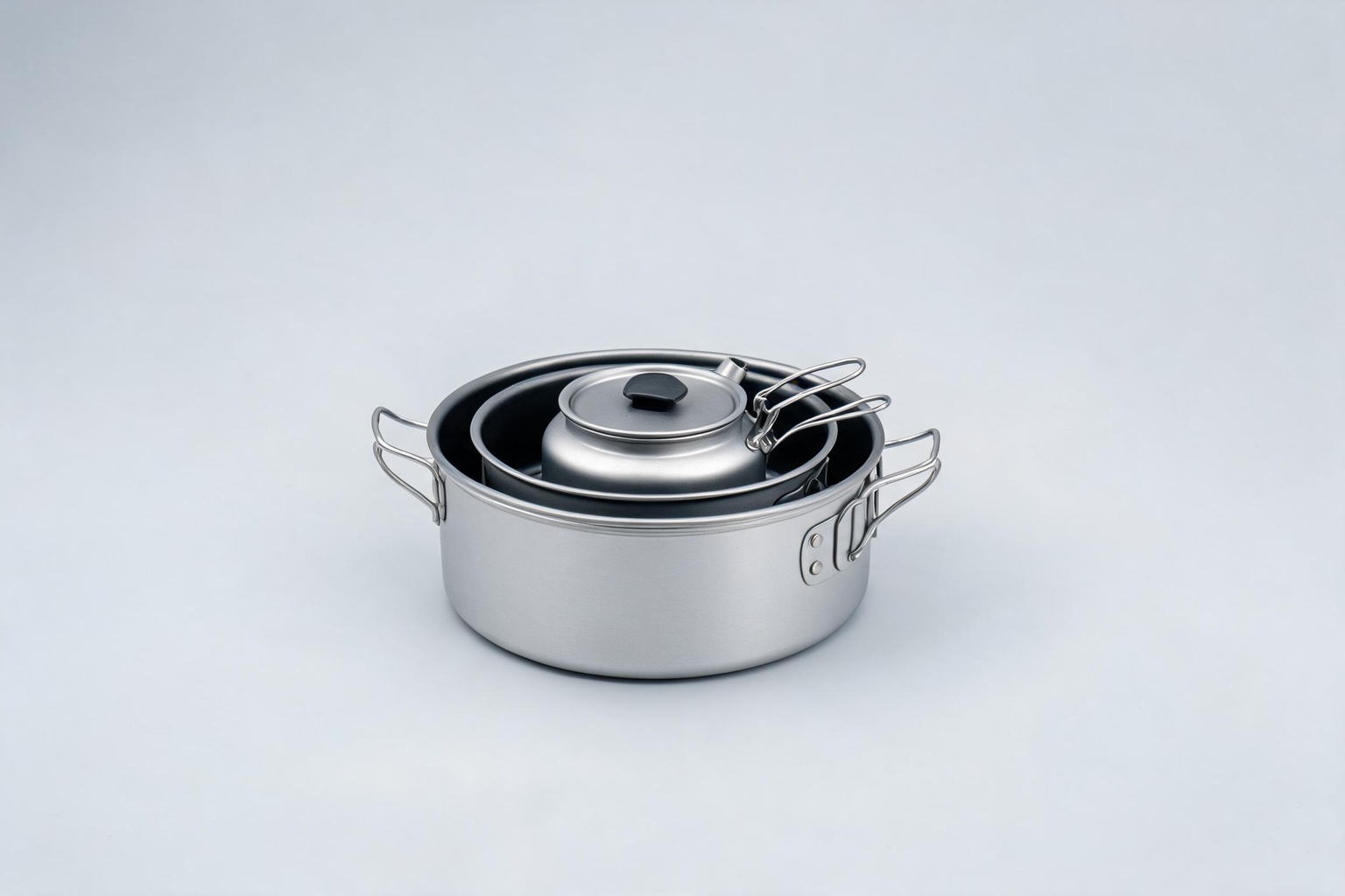 Nested camping cookware set with anodized aluminum pot, pan and kettle